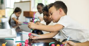 two children collaborating on a science project at a lab table