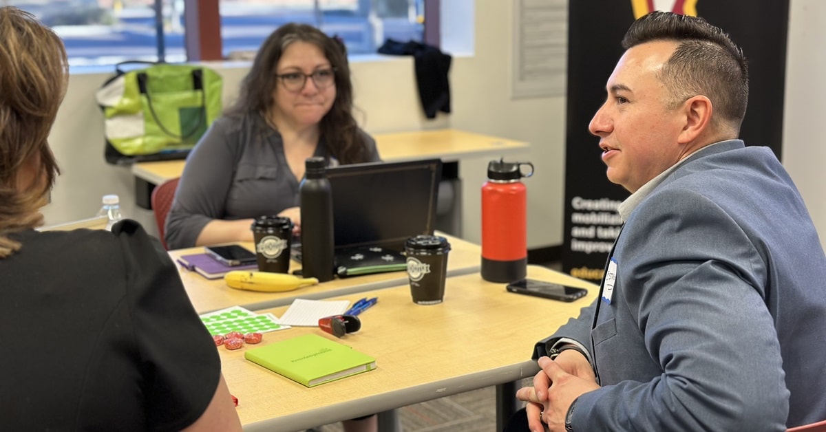 Lead for Learners steering committee members Hector Estrada, Christina Guevara and Jeni Gotto converse at a table