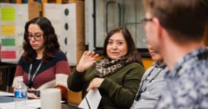 Educators sit at a table in discussion