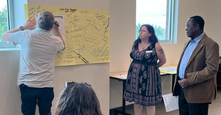 Education constituents gather at a large paper poster on the wall with a lot of ideas written on it