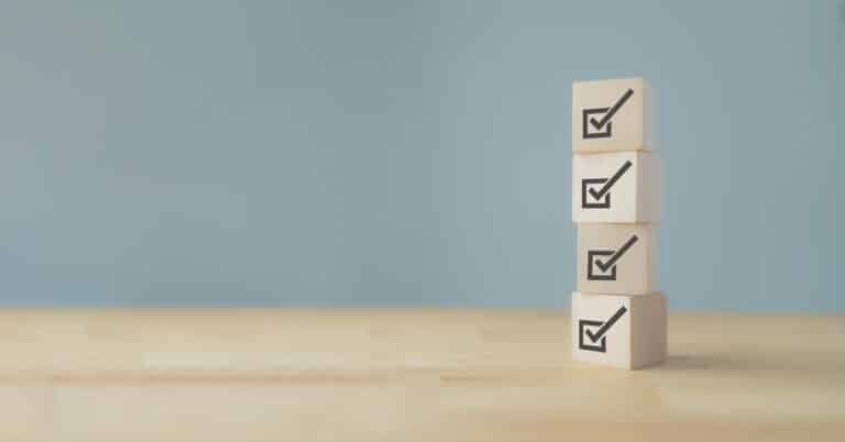 a stack of wooden blocks with check marks in boxes
