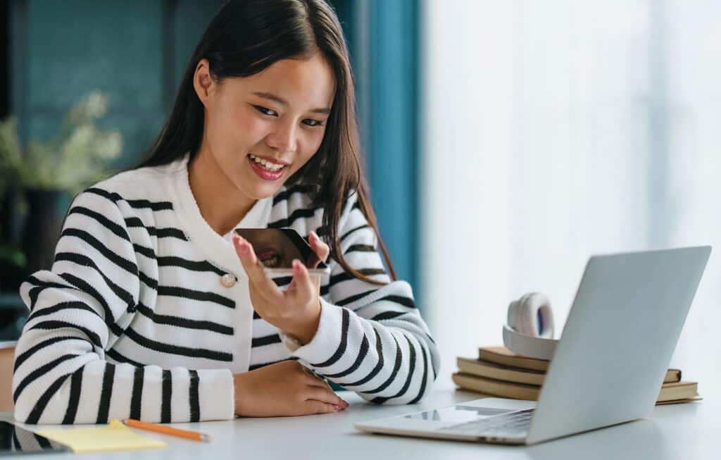 Asian woman using voice assistant AI learning on smartphone